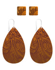 Teardrop-shaped earrings with intricate Maori inspired brown pattern.